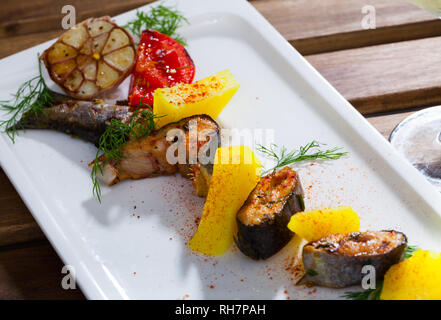 Appetitlich gebackene Forellen Steaks mit Kartoffeln und Kräuter auf dem Teller serviert. Stockfoto