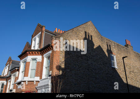 Der Schatten der Schornsteine eines Nachbarn auf der Seite einer End-of-terrace Haus in South London, am 30. Januar 2019, in Herne Hill, Lambeth, London, England. Stockfoto