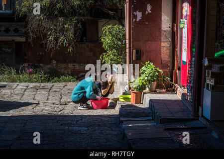 Man waschen sein Gesicht in einem Kanal, Altstadt von Lijiang, historische Stadt, Provinz Yunnan, China Stockfoto