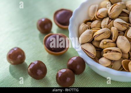 Schüssel von Pistazien mit Schokolade bombons und Karamell Bonbons. Stockfoto