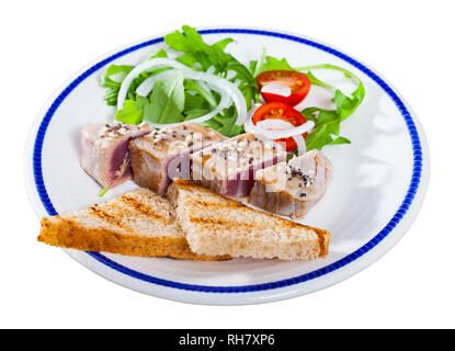 Lecker leicht gebratener Thunfisch mit Sesam auf Platte mit Toast, frische Tomaten und grünen serviert bestreut. Auf weissem Hintergrund Stockfoto