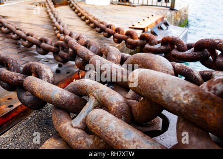 In der Nähe von alten rostigen Kette, industrielle Hafen mit chainss, Kran Hintergrund unscharf, sonnigen Tag, industrielles Konzept Stockfoto