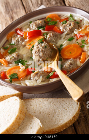 Italienische Hochzeit Suppe mit orzo Pasta, Frikadellen und Gemüse close-up auf dem Tisch. Vertikale Stockfoto