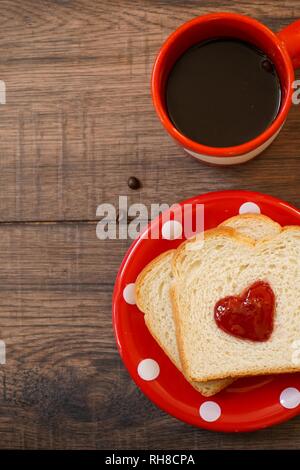 Valentines Tag Frühstück im Bett Sandwich mit roter Marmelade Herz/Cookies auf einem weißen trayon rote Platte, Ansicht von oben Stockfoto