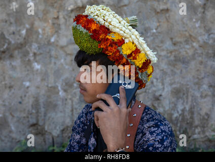 Porträt einer Blume junger Mann auf seinem Handy anrufen und das Tragen eines floralen Krone auf dem Kopf, Provinz Jizan Addayer, Saudi-Arabien Stockfoto