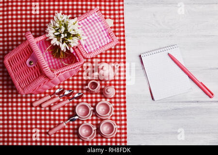 Picknick Card mit Tisch und Besteck, rosa weiß überprüft Serviette, weiß Rustikal Vorstand Hintergrund, leeren Raum für Text. Stockfoto