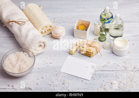 Bar der selbstgemachte Seife, chemische Lavendelblüten und ätherisches Öl. Ansicht von oben. Natürliche kosmetische Öl, Meersalz und handgemachte Seife auf hellen Hintergrund. Aromathe Stockfoto