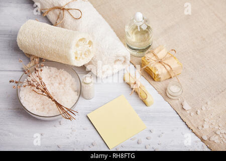 Bar der selbstgemachte Seife, chemische Lavendelblüten und ätherisches Öl. Ansicht von oben. Natürliche kosmetische Öl, Meersalz und handgemachte Seife auf hellen Hintergrund. Aromathe Stockfoto
