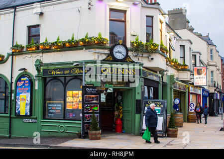 14 Decemberv 2018 ein Gönner verlassen Quinn's Irish Pub in Newcastle, County Down nach ein paar bevvies auf einem Mitte Winter am Nachmittag Stockfoto