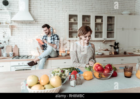 Strahlende junge hübsche Frau mit großen Ohrringe suchen zufrieden Stockfoto