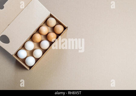 Blick von oben auf die Karton ei Container mit 15 Eier auf einem braunen Hintergrund. Stockfoto