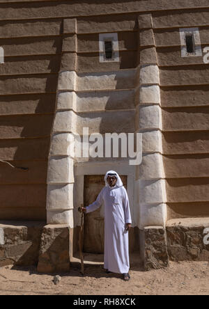 Saudi Mann, der vor einem traditionellen alten Lehmhaus, Najran Provinz Najran, Saudi-Arabien Stockfoto