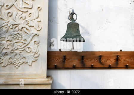 In der Nähe der weißen Wand und alte Metall Glocke auf es Stockfoto