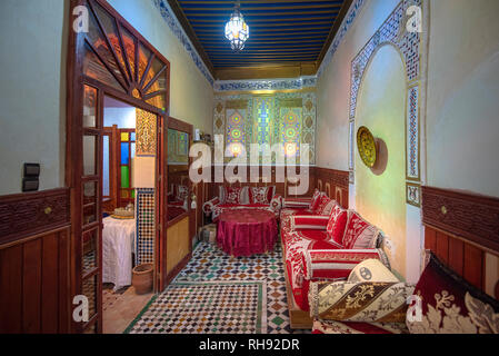 Innenhof mit gefliesten Wänden und Fußboden aus Mosaik. Traditionelle verzierten und farbenfrohe Arabesque wand Schnitzereien in den marokkanischen Riad. Im Innenraum Stockfoto