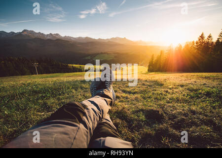 POV eines Mannes liegen auf einer Wiese in den Bergen Stockfoto