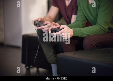 Zwei junge Männer spielen Halten eines Joysticks Stockfoto