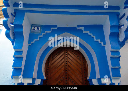 Typische, Alte, braune kunstvoll geschnitzten, Nieten, marokkanische Riad Tür und Tür-Rahmen und altes Haus. blaue Stadt in der Medina von Meknes, Marokko Stockfoto