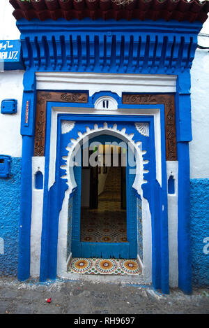 Typische, alt, blau kunstvoll geschnitzten, Nieten, marokkanische Riad Tür und Tür-Rahmen und altes Haus in die blaue Stadt in der Medina von Meknes, Marokko Stockfoto