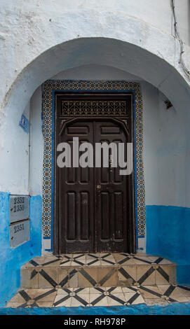 Typische, Alte, braune kunstvoll geschnitzten, Nieten, marokkanische Riad Tür und Tür-Rahmen und altes Haus. blaue Stadt in der Medina von Meknes, Marokko Stockfoto