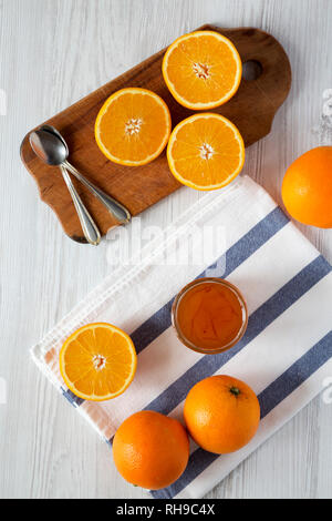 Hausgemachte Orangenmarmelade über weiß Holz- Hintergrund, Ansicht von oben. Flach, Overhead, von oben. Stockfoto