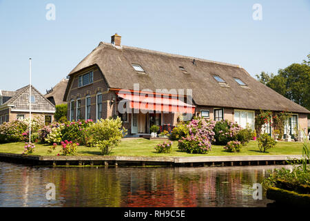 Das reetgedeckte Haus mit schönen Garten in märchenhaften Dorf Giethoorn in den Niederlanden. Stockfoto