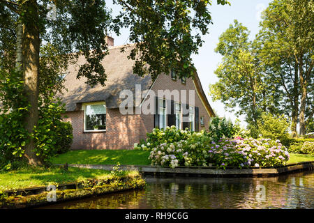 Das reetgedeckte Haus mit schönen Garten in märchenhaften Dorf Giethoorn in den Niederlanden. Stockfoto