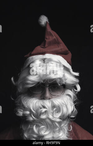 Low Key Schuß von Santa Claus mit Brille vor schwarzem Hintergrund Stockfoto