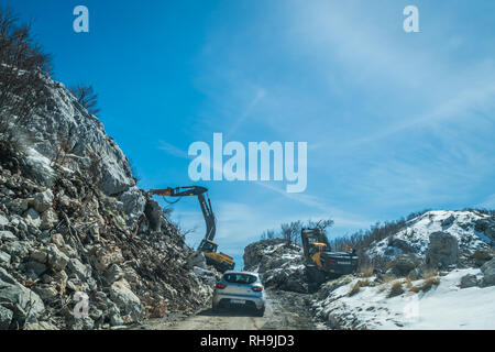 Nationalpark Lovcen, Montenegro - April 2018: Die weissen Pkw warten auf der Straße der kleinen Erdrutsch im Winter zu gelöscht werden. Stockfoto