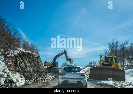 Nationalpark Lovcen, Montenegro - April 2018: Die weissen Pkw warten auf der Straße der kleinen Erdrutsch im Winter zu gelöscht werden. Stockfoto