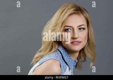 Close-up Studio Portrait von eine schöne blonde Frau mittleren Alters. Grau backgroundClose-up Studio Portrait von eine schöne blonde Frau mittleren Alters. Gra Stockfoto