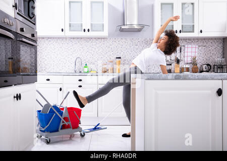 Nahaufnahme einer jungen afrikanischen Frau rutscht beim Wischen in der Küche Stockfoto