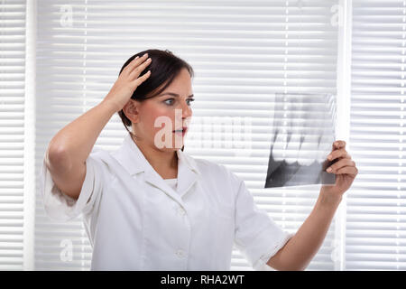 Weiblichen Zahnarzt Suchen der Zahn X-ray In der Klinik stehen Schockiert Stockfoto