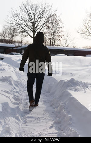 Mann geht in den Schnee Stockfoto