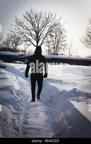 Mann geht in den Schnee Stockfoto