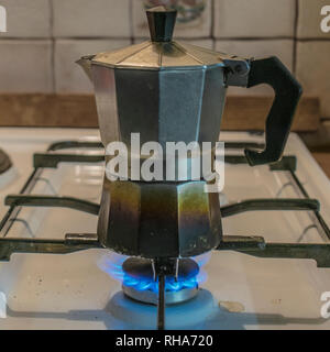 Kaffee mokka Topf auf einem brennenden Gasherd in der Küche. Stockfoto