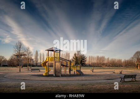 Leer, Kinderspielplatz und Bänke vor dem Sonnenaufgang an einem Wintertag Stockfoto