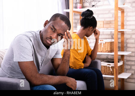 Junge gedrückt Afrikanischen Paar sitzt auf einem Sofa Stockfoto