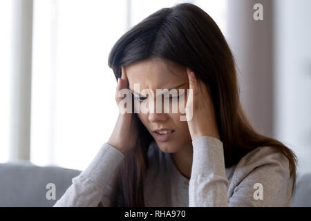 Verärgert betonte junge Frau Gefühl Schmerz starke Kopfschmerzen Konzept Stockfoto