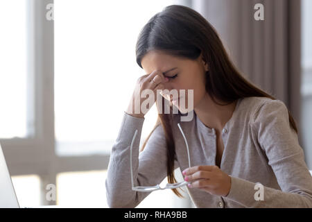 Überarbeitet müde junge Studentin holding Gläser Gefühl Belastung der Augen Stockfoto