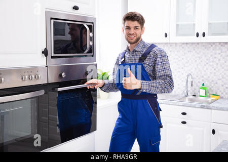 Nahaufnahme eines männlichen Techniker In der Küche zeigen Daumen nach oben Geste stehend Stockfoto