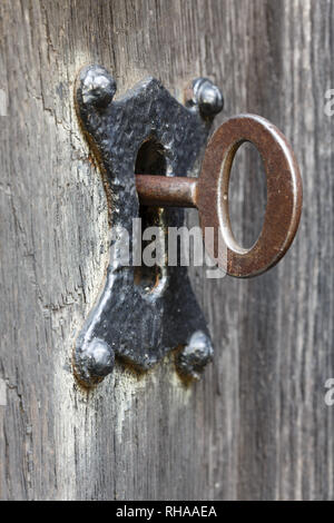 Alte Schlüssel in das Schlüsselloch. Zeigt Konzepte von Sicherheit und Verschlüsselung Stockfoto
