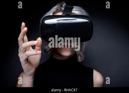 Frau trägt eine futuristisch anmutende virtual reality Headset Schutzbrillen. Das Gerät ist eine Technologie, mit der Video gamers Erfahrung VR oder AR rea Augmented Stockfoto