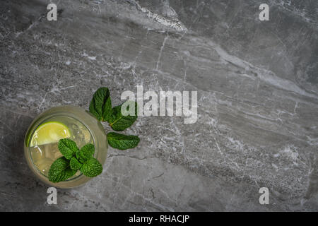 Ein Foto von einem Glas mojito Cocktail mit Eis auf einem hellen Mable rock Hintergrund Stockfoto