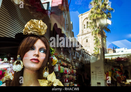 Granada, Andalusien, Spanien: Fenster mit weibliche Schaufensterpuppe in Rocio Flamenco Mode und Reflexionen von der Kathedrale und dem historischen Zentrum von Granada Stockfoto
