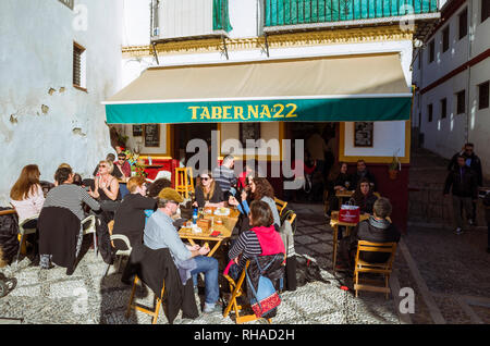 Granada, Andalusien, Spanien: Einheimische und Touristen in der Sonne sitzen im Freien Terrasse bar Taberna El 22 im Unesco Weltkulturerbe Altstadt Albaicin. Stockfoto