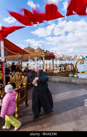 Istanbul, Türkei: eine Frau und ein Kind vorbei ein Fisch Kebab schwimmenden Restaurant am Goldenen Horn. Stockfoto