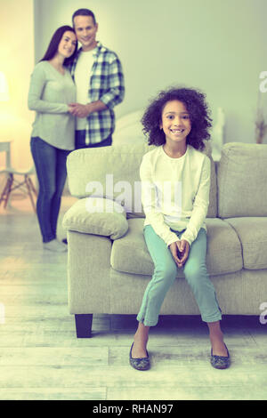 Liebevolle Eltern umarmen im Hintergrund ihre Tochter suchen. Stockfoto