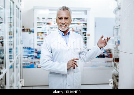 Reifer Mann mit Gesichts Falten in seiner Apotheke ständigen Bärtigen Stockfoto