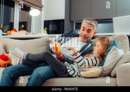 Adorable kleine langhaarige Mädchen und ihr Vater auf der Suche besetzt Stockfoto