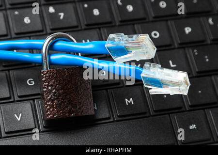 Beschränkung des Zugangs zum Internet. Kabel Twisted Pair und Sperren auf der Tastatur des Laptops. Stockfoto